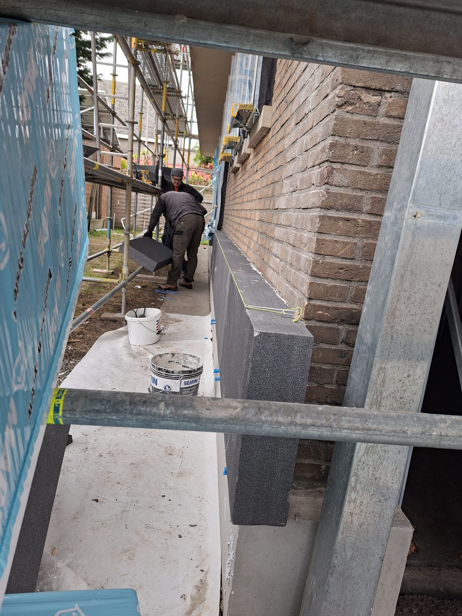Equipo trabajando en fachada con aislamiento
